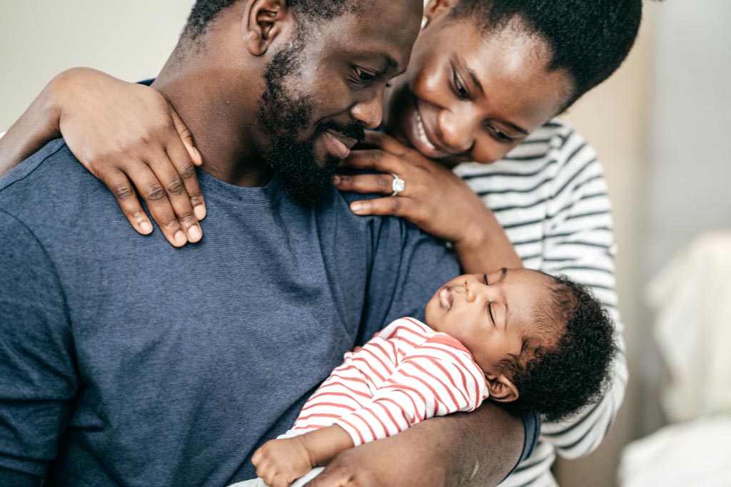 New parents holding their baby and adjusting to life as a family